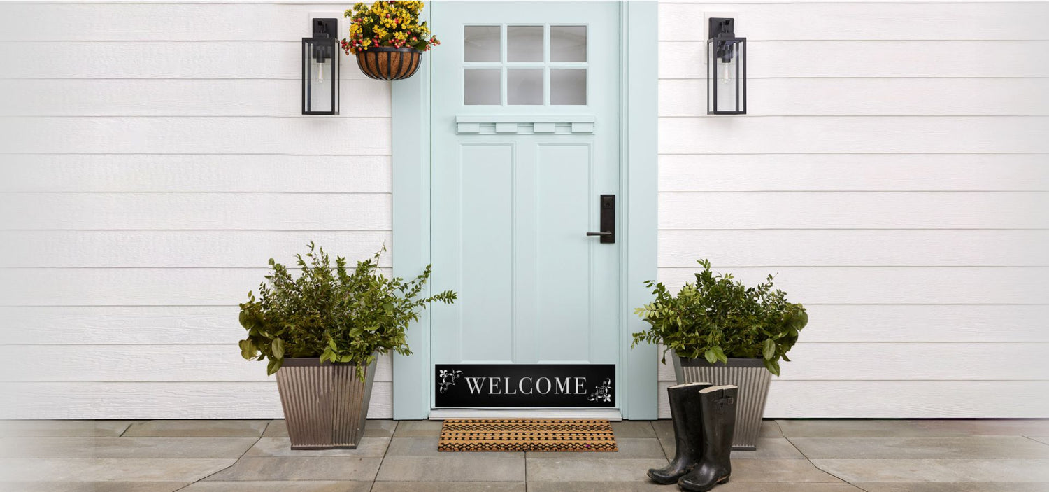 Light blue front door with satin black "Welcome" engraved kick plate